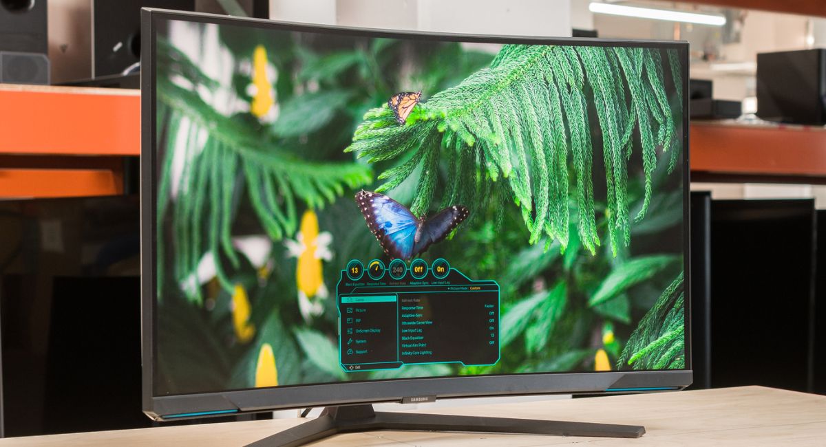 مانیتور Odyssey Neo G8 سامسونگ روی میز در حال نمایش پروانه روی گیاه